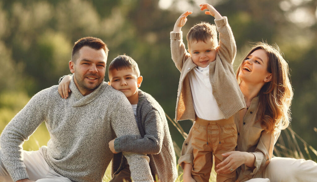 Happy parents playing with their child outdoors after receiving an Australian Child Visa